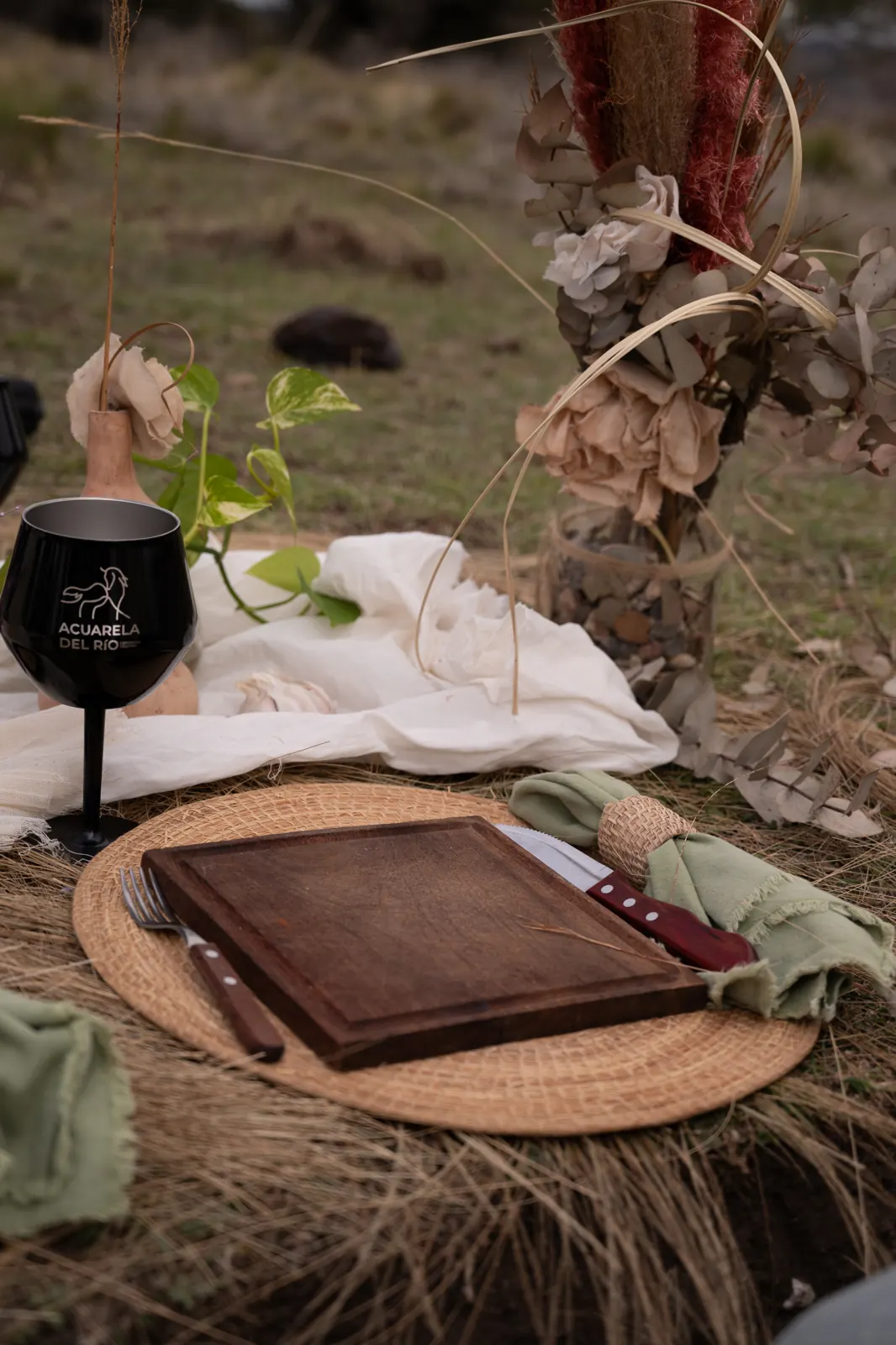 Un lugar preparado con vajilla de madera, textiles y flores